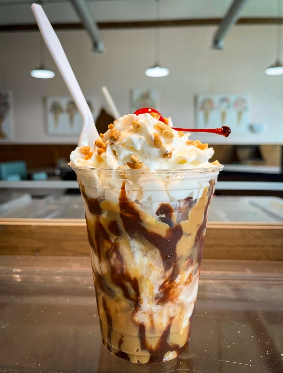 Peanut butter and chocolate sundae with whipped cream, nuts and a cherry